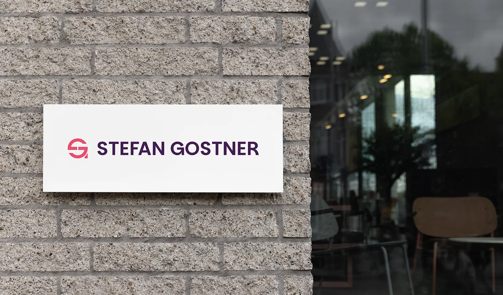 Stefan Gostner Logo auf Schild an Hauswand